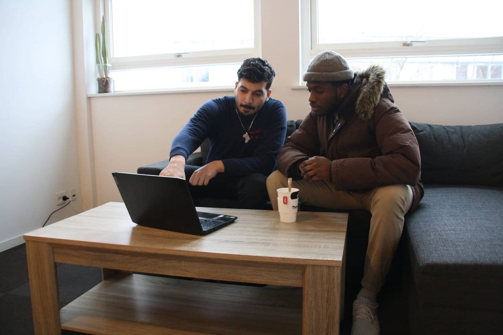 To personer samarbejder foran en bærbar computer