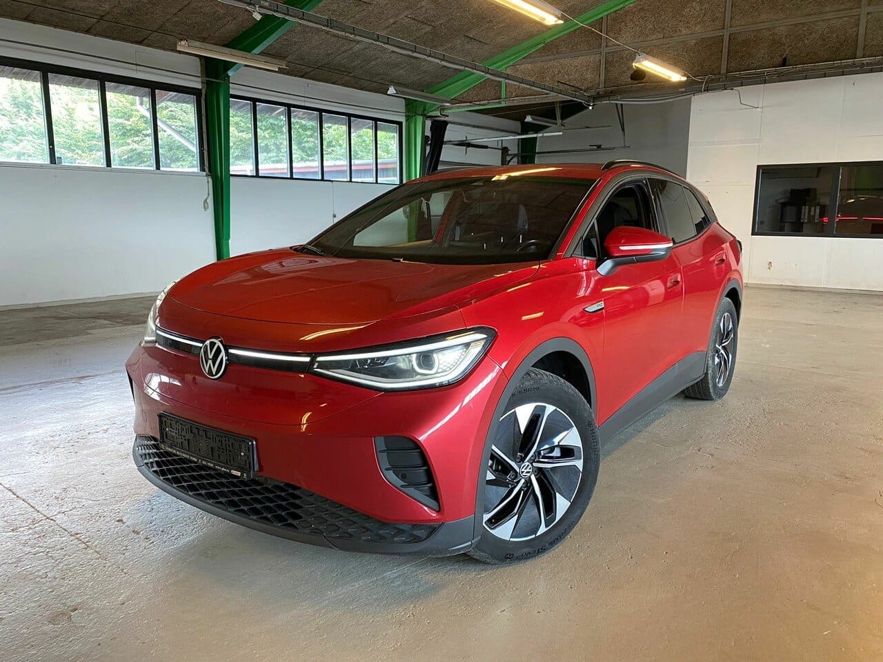 Rød Volkswagen elbil parkeret i garage