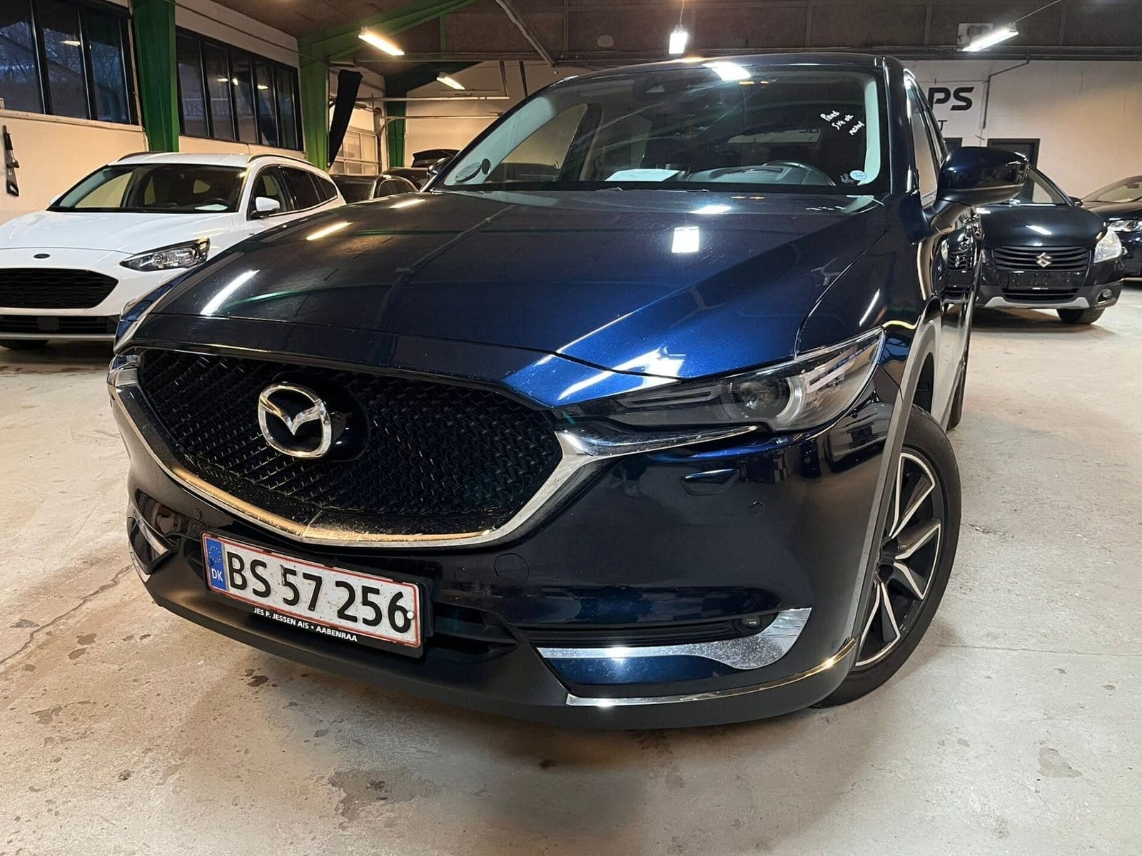 Blå Mazda SUV parkeret i biludstilling
